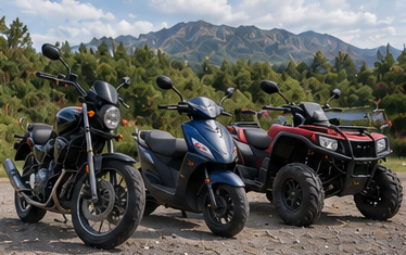 A motorcycle, motor scooter and ATV parked together on a gravel forecourt